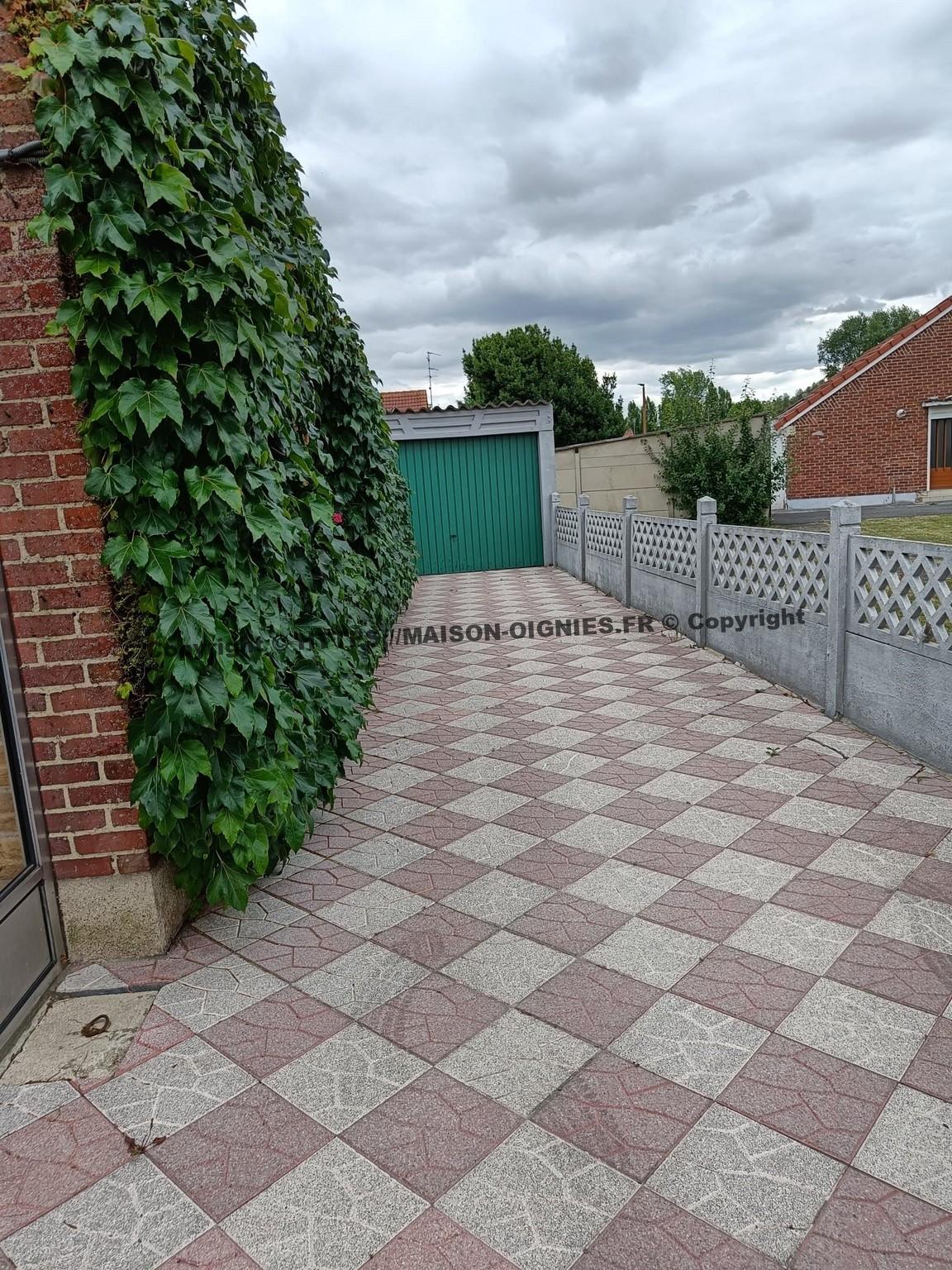 l'image montre une allée large pour entrée de voitures vers le garage et accès arrière à la maison et au jardin