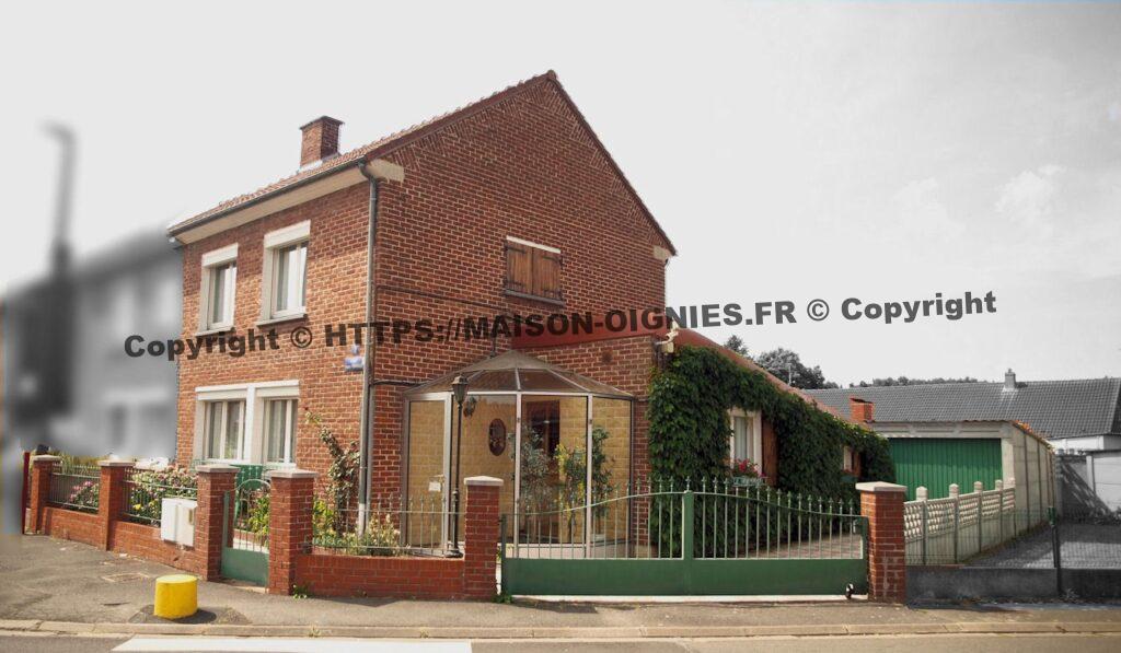 Vue de trois-quarts, de la maison qui montre la maison, le sas vitré de l'entrée, les portillon et portail d'accès pour les voitures et l'arrière de la maison et le jardin, le portail s'ouvre en pivotant, s'alignant sur le mur qui donne dans la salon et la cuisine, l'entrée est alors entièrement dégagée, pratique pour des livraisons de grande taille, qui ne se font pas sur la route.