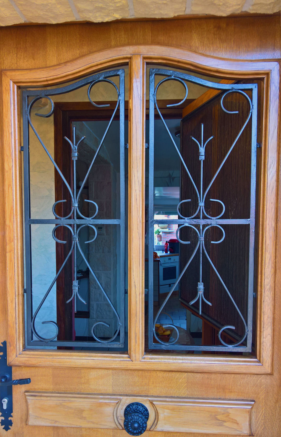 fenêtre de la porte d'entrée ouverte, la grille reste en place